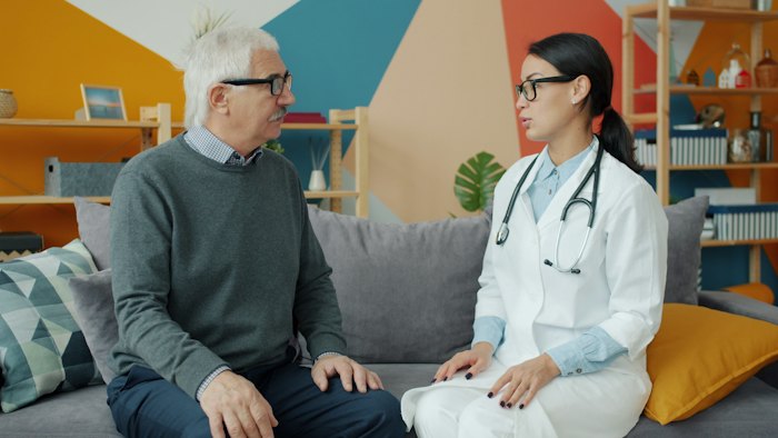 Professional talking with an older person on a couch