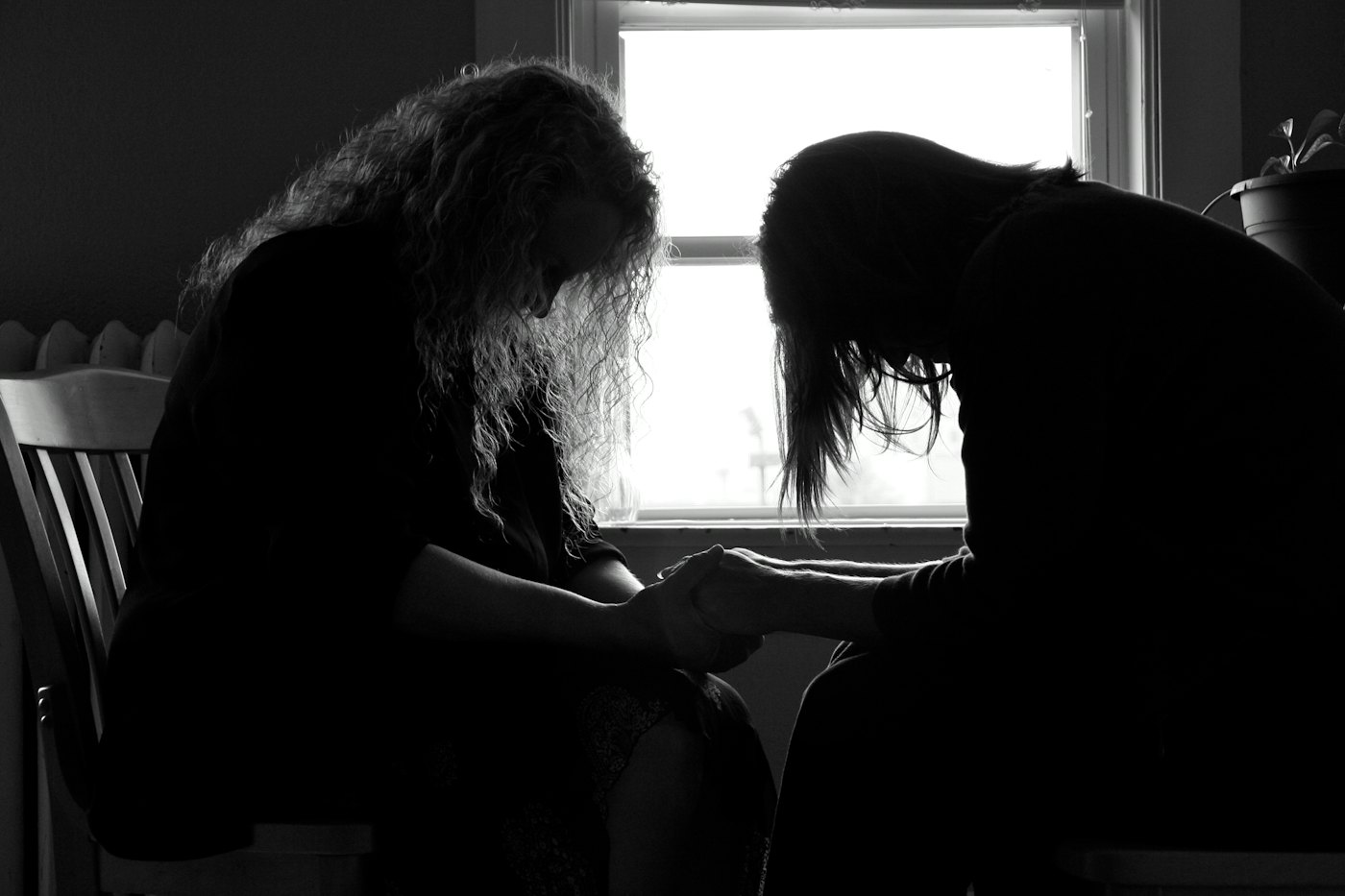 Two women sitting together holding hands