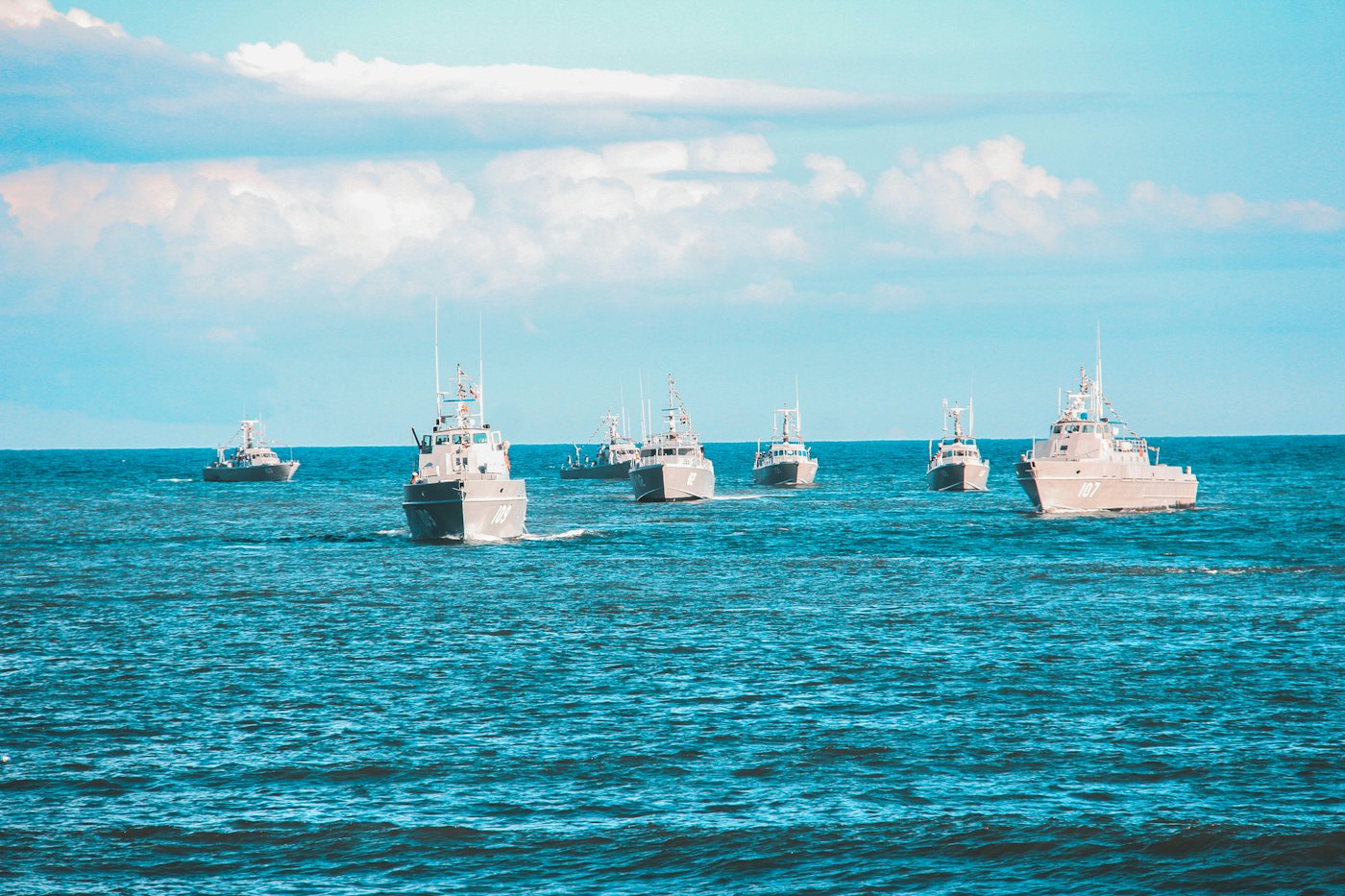 Navy ships sailing in formation on the ocean