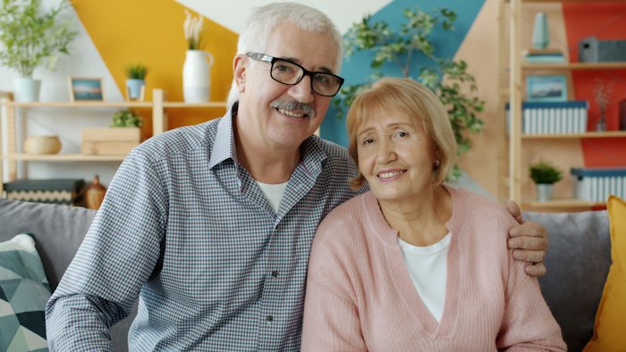 Older couple smiling together on a couch